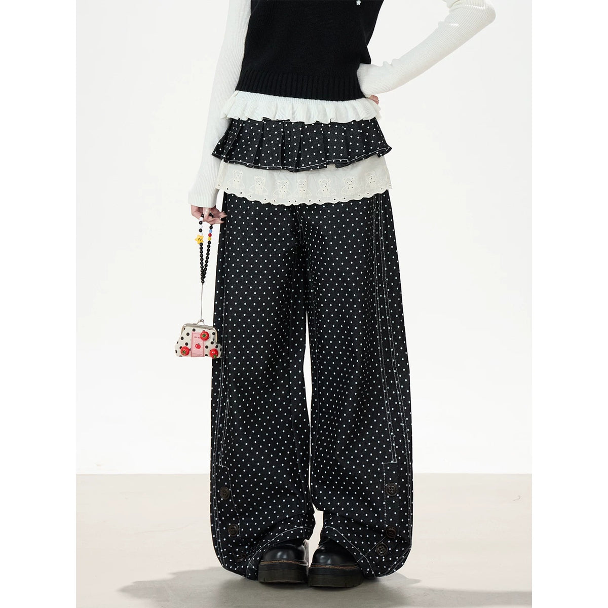Gestrickte Weste mit Blumenknöpfen, weißes Langarmshirt zum Drunterziehen & schwarze Hose mit weitem Bein