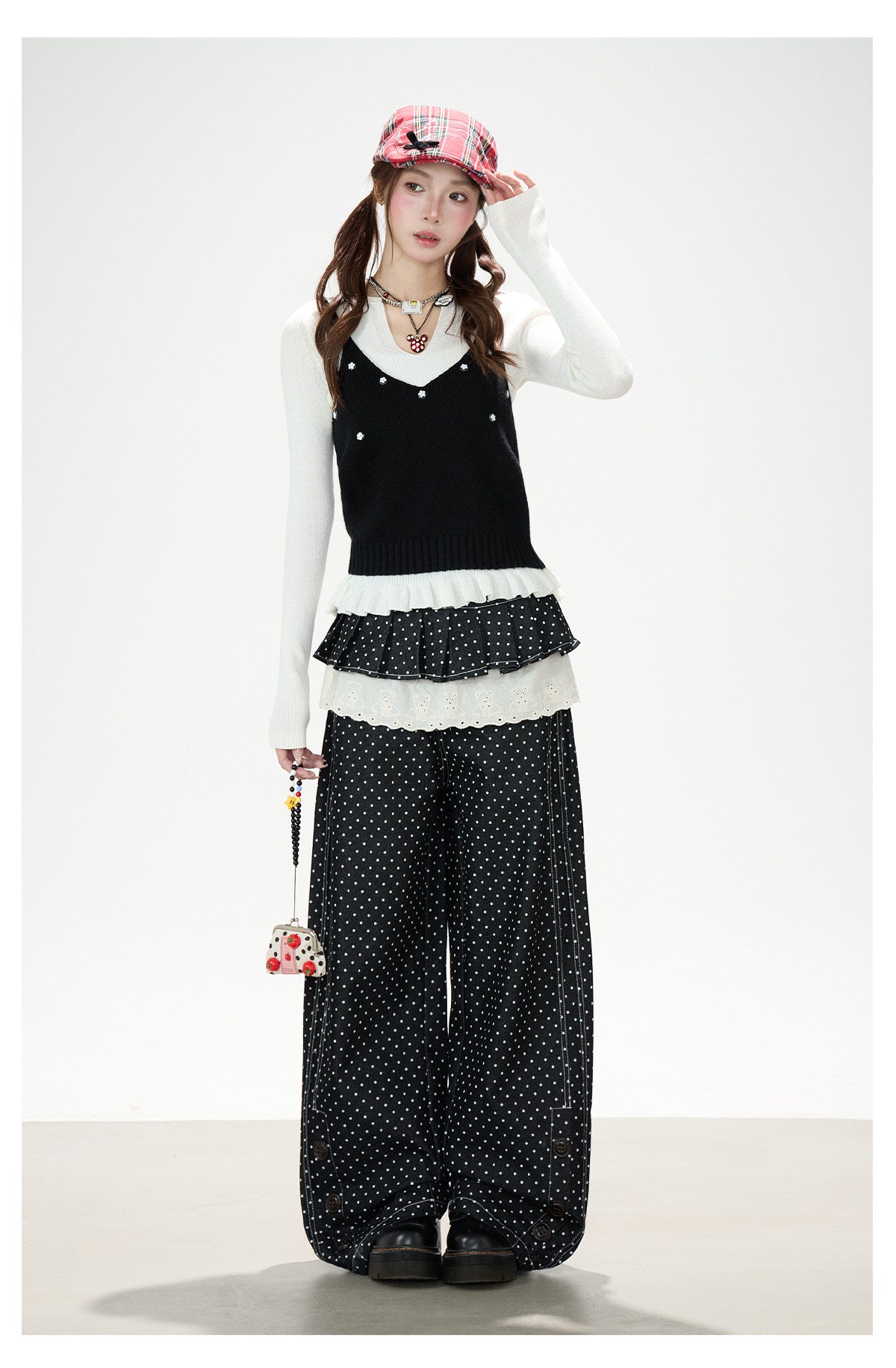 Gestrickte Weste mit Blumenknöpfen, weißes Langarmshirt zum Drunterziehen & schwarze Hose mit weitem Bein